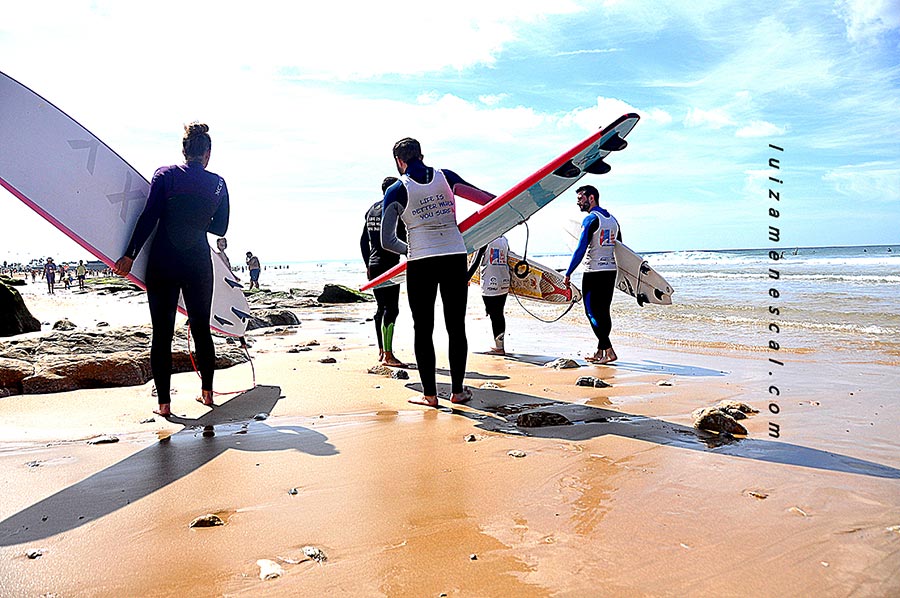 lisbon-surf-camp-cascais-surfers-carrying-surfbaords-on-beach
