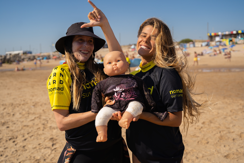 happy girl with baby nomad surf camp - young adults - lisbon - erasmus - university students retreats for adults surf camp lessons children teen summer young adult best nomad kid bali canggu beginners uluwatu france moliets portugal algarve